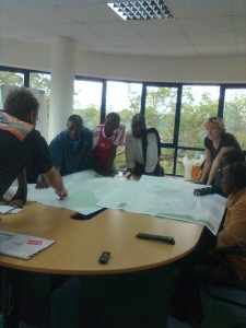 Map Kibera team reviews printed map (in draft stages) of their work