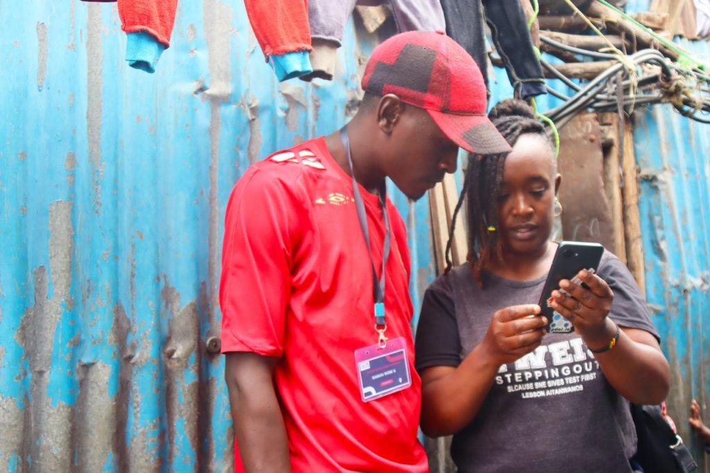 Our field coordinator Lucy demonstrating to one of the enumerators how to pick accurate gps coordinate. 